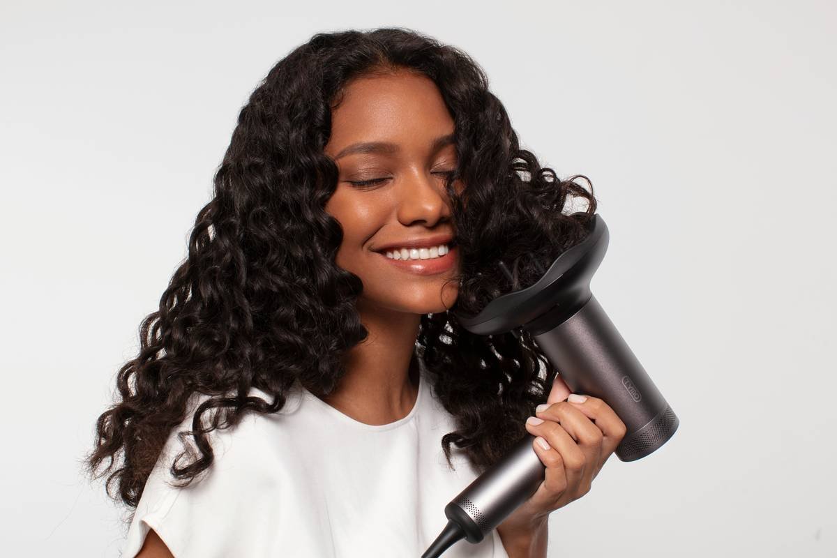 anti-frizz serum women applying smoothing serum to damp hair