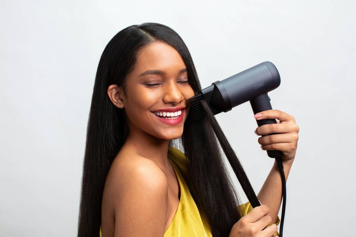 Woman applying hair cleanser frizz product with smooth results