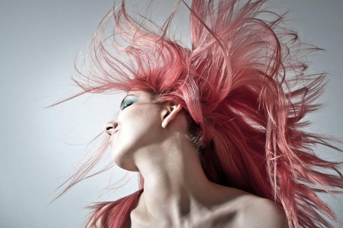 Woman applying anti-frizz hair cleanser in shower with smooth hair result