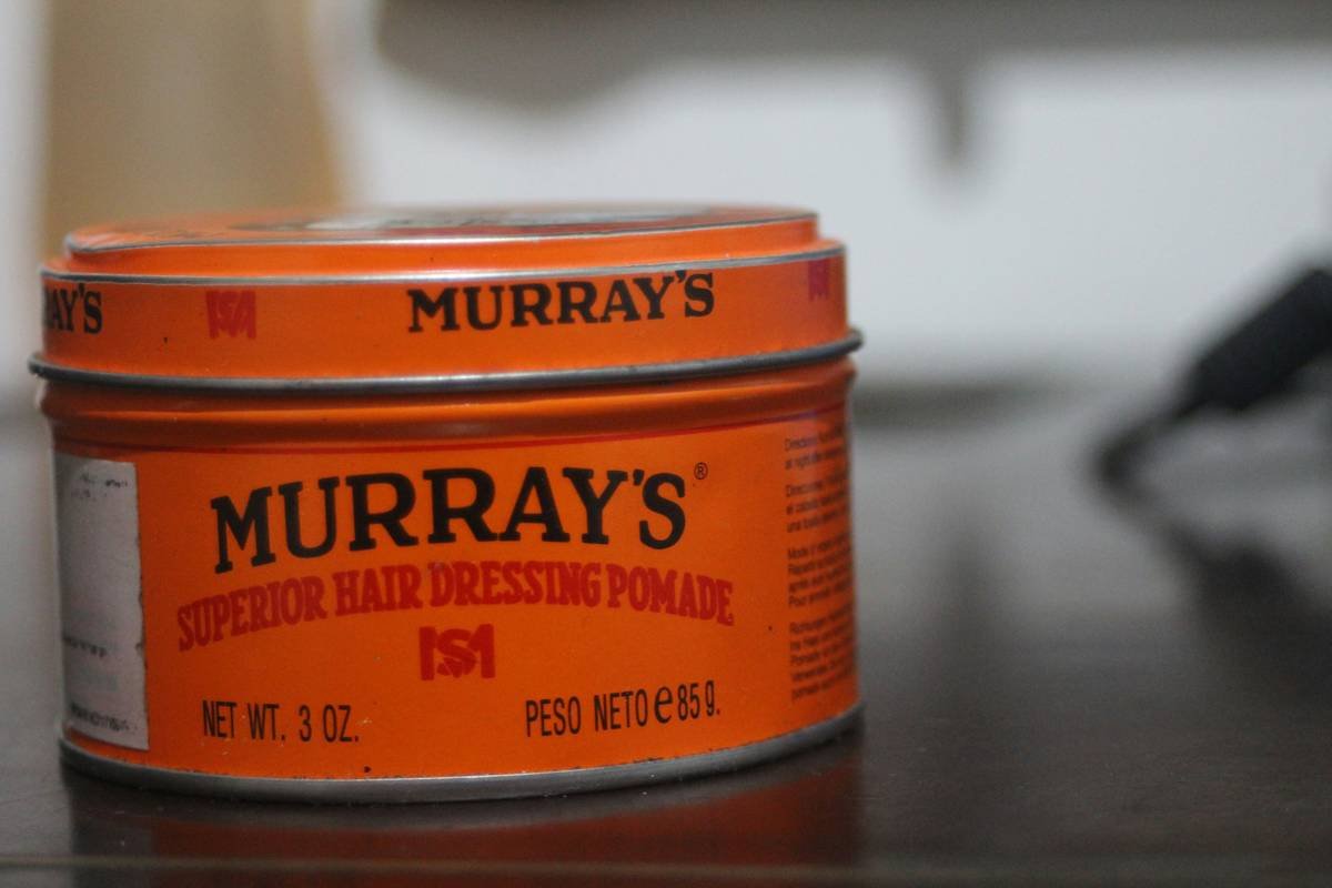 Applying anti-frizz hair pomade to damp hair for smooth, controlled styling